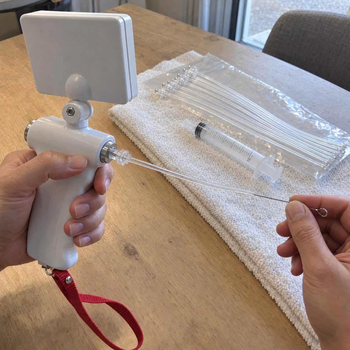 The steel guide wire being drawn out of a tube whose clear fitting sits at the back of the Kiba Scope
