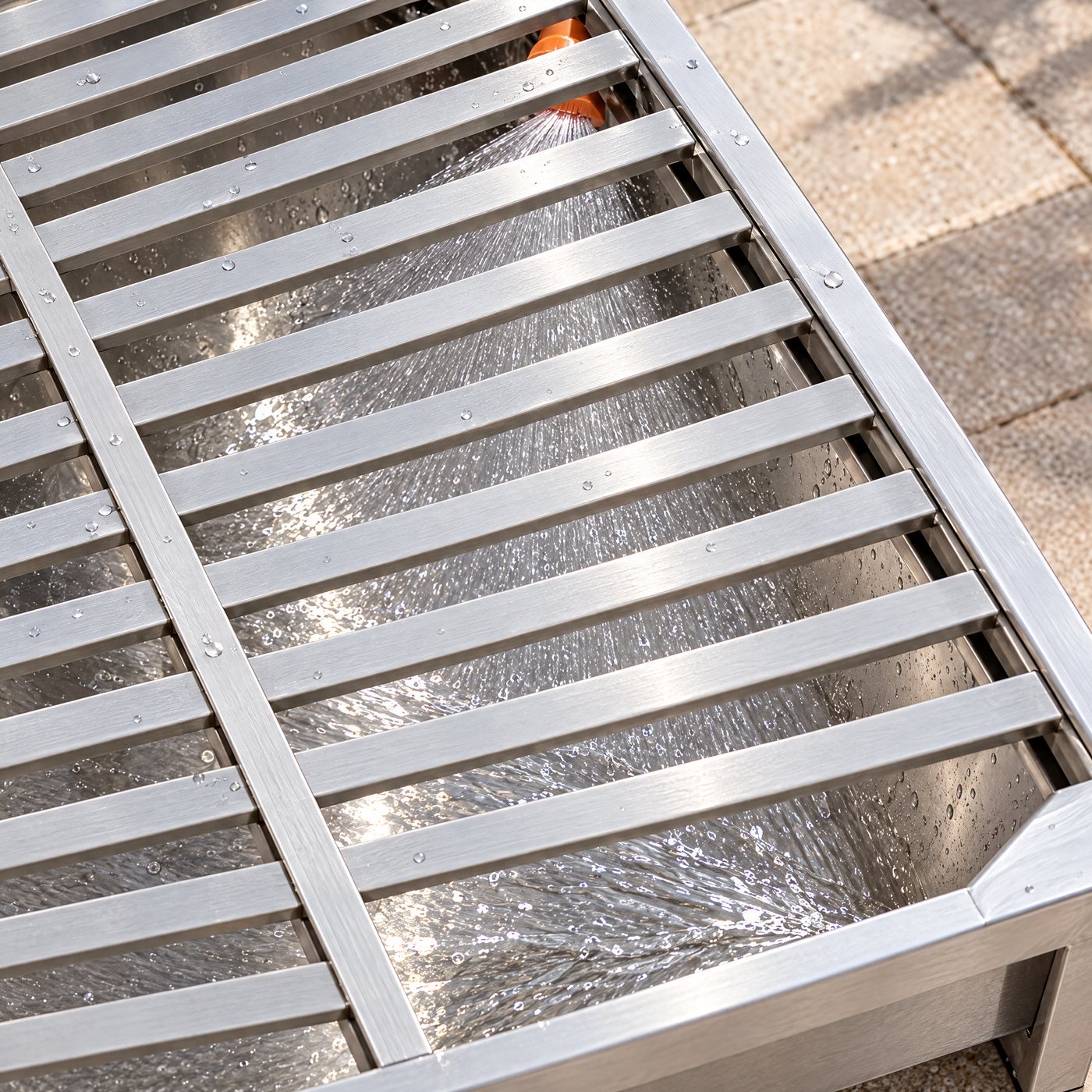Looking down through the slats of the Kiba Rinse at water fanning across the pan below