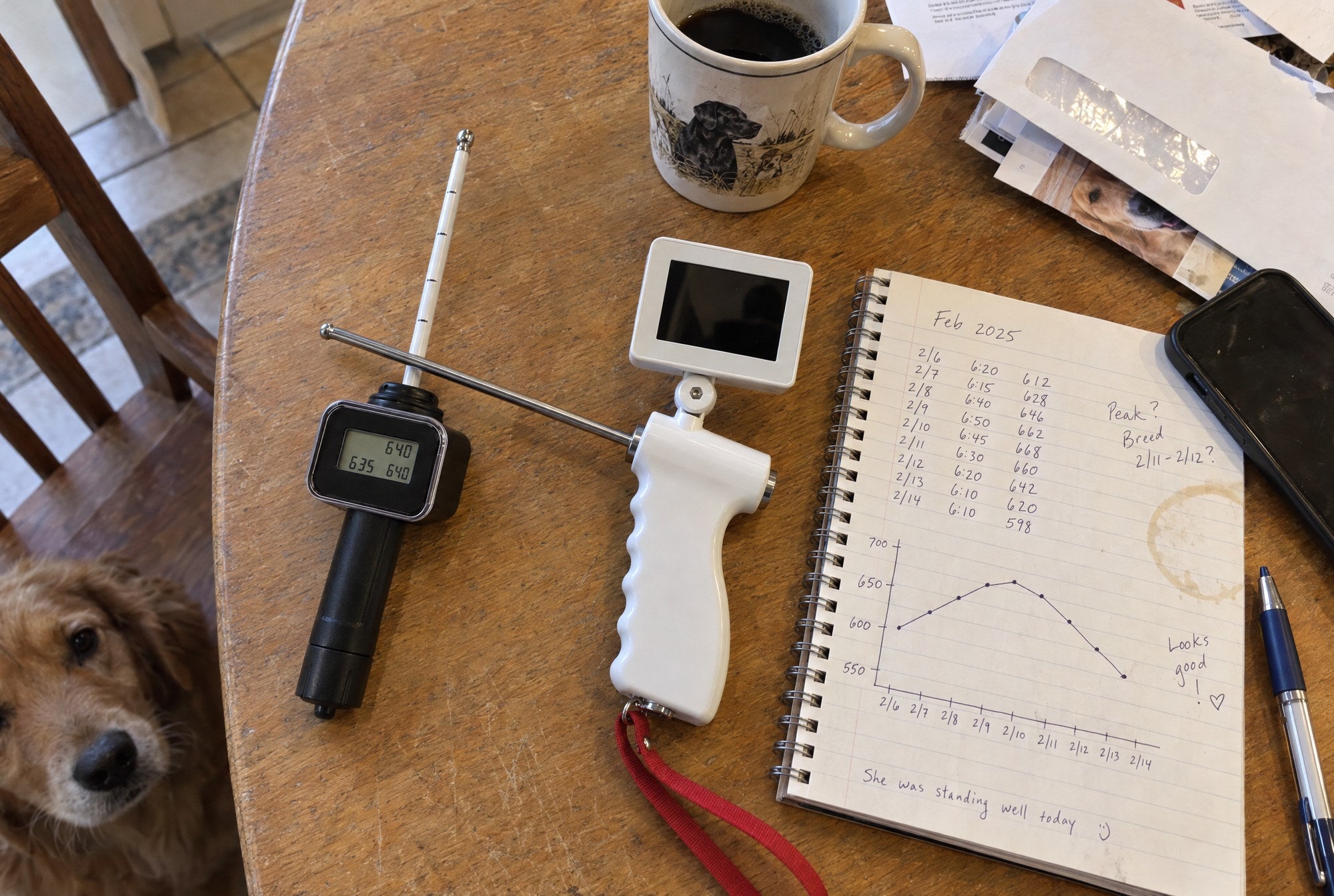 Kiba Season ovulation meter and Kiba Scope camera insemination kit side by side on an oak table, a notebook with a reading chart beside them